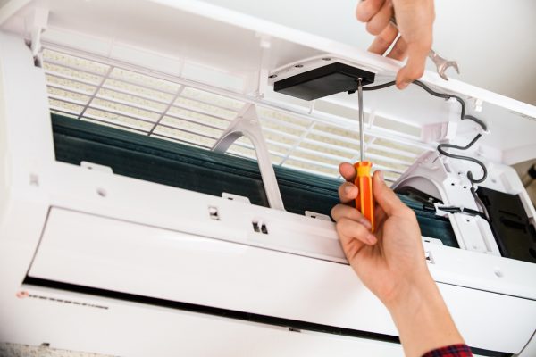 Service man is cleaning, repair and maintenance of air conditioner